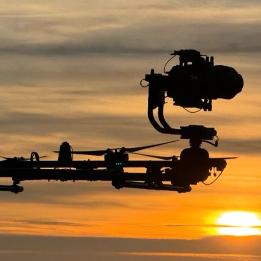 Close-up of the Blackmagic URSA Cine Immersive camera with dual lenses mounted on a custom drone gimbal at sunset.